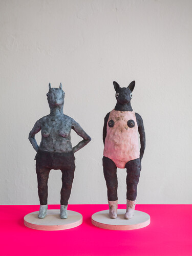 Zwei Keramikfiguren mit menschlichen Körpern und Tierköpfen.